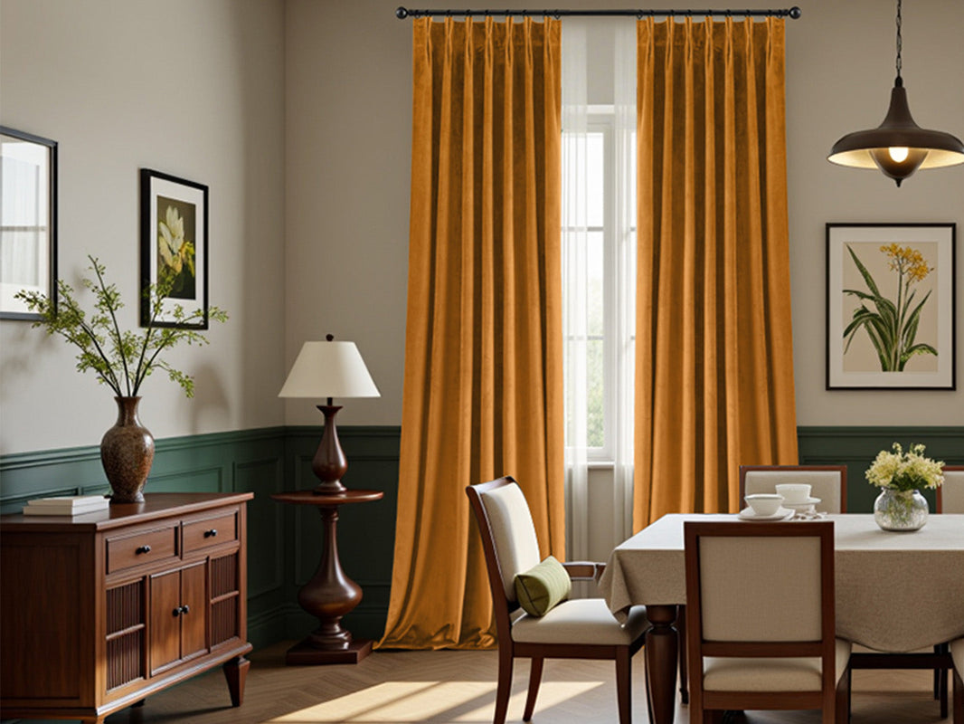 Mustard yellow velvet curtains in a classic dining room with dark green wainscoting and wooden furniture.