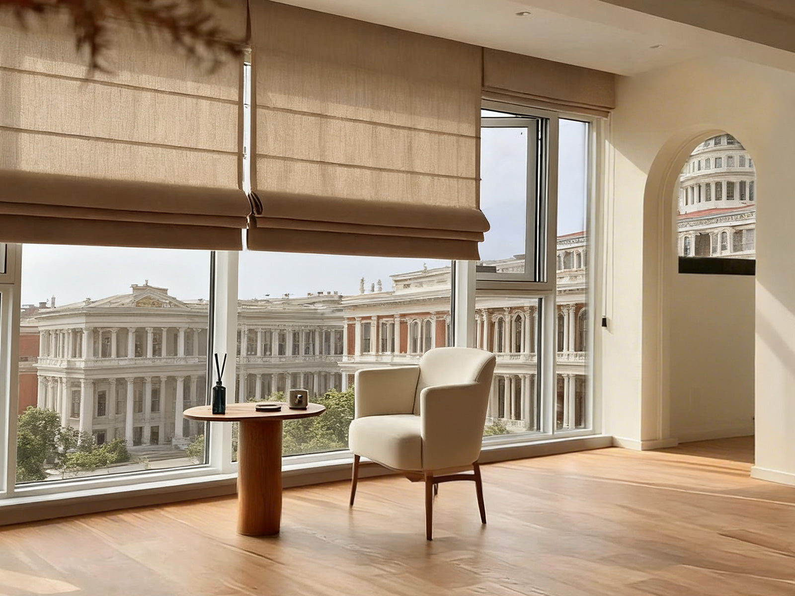 A modern room with large windows featuring beige Roman shades, overlooking classical architecture.