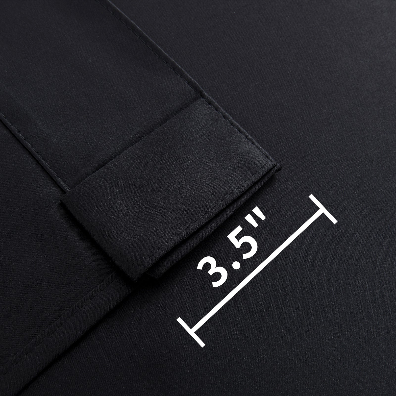 Close-up of Joydeco black blackout curtain fabric showing 3.5-inch back tab for hanging options.