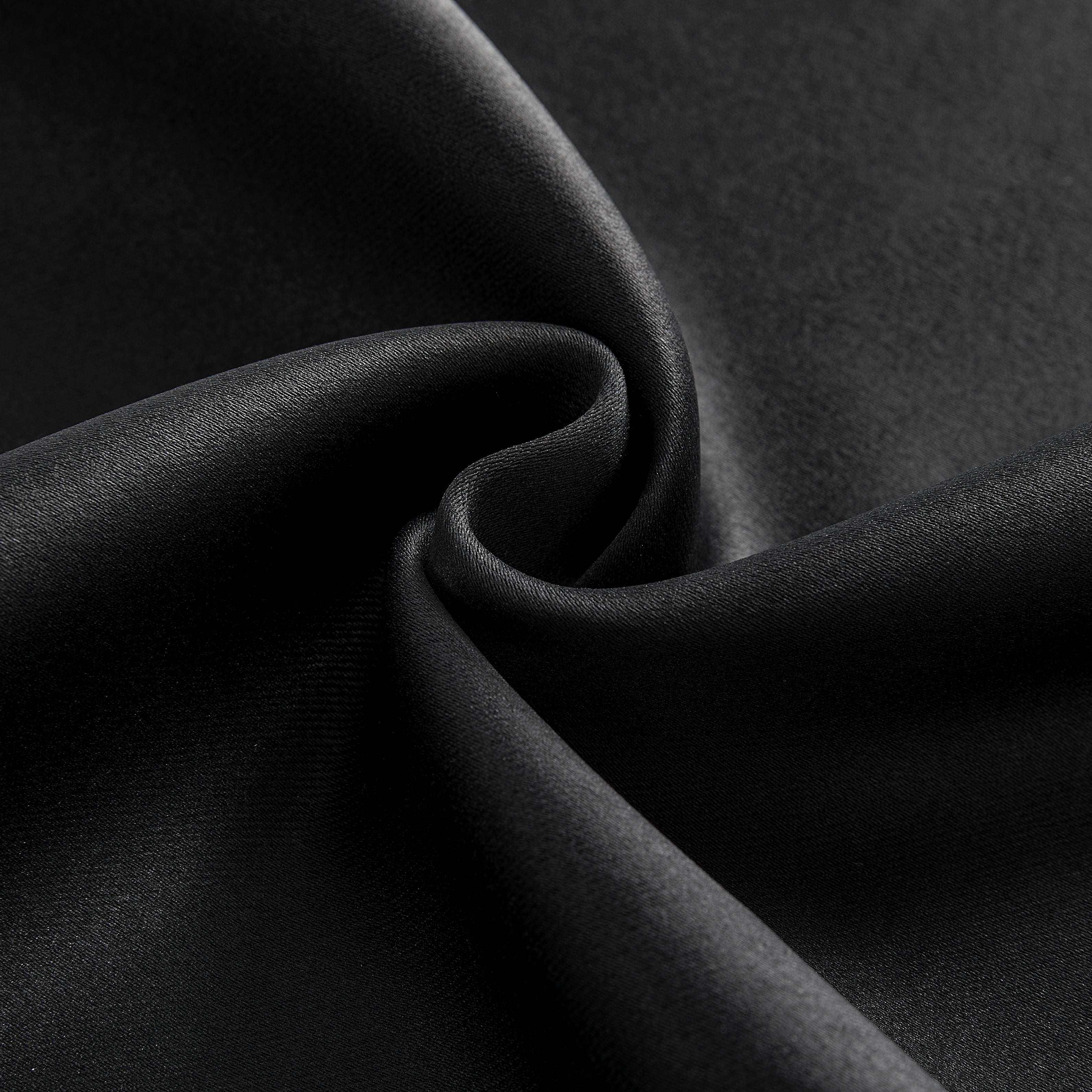 Close-up black blackout curtain fabric texture, dense polyester weave, matte finish, soft folds for room darkening.