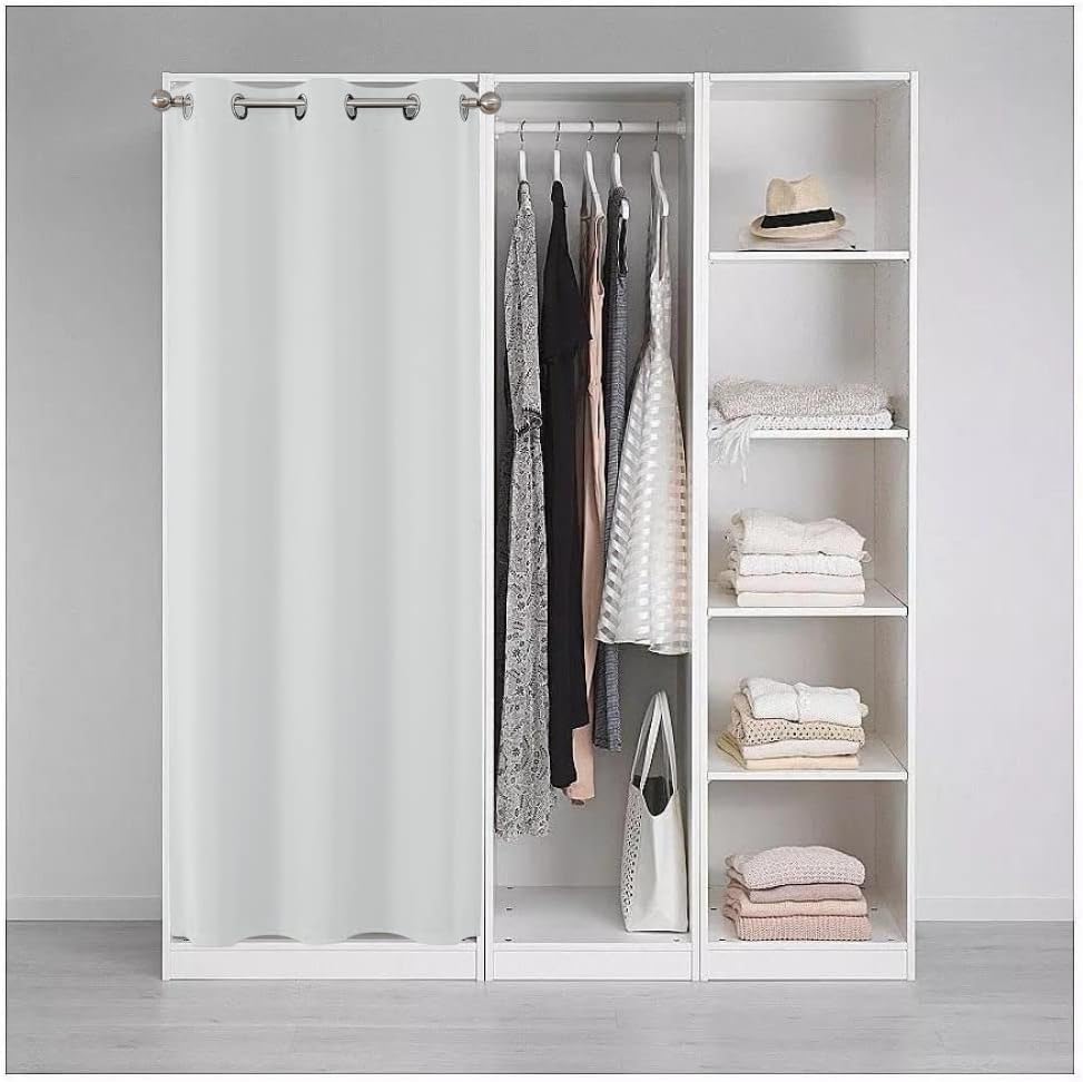 White blackout curtain as room divider for closet with clothes and shelves.