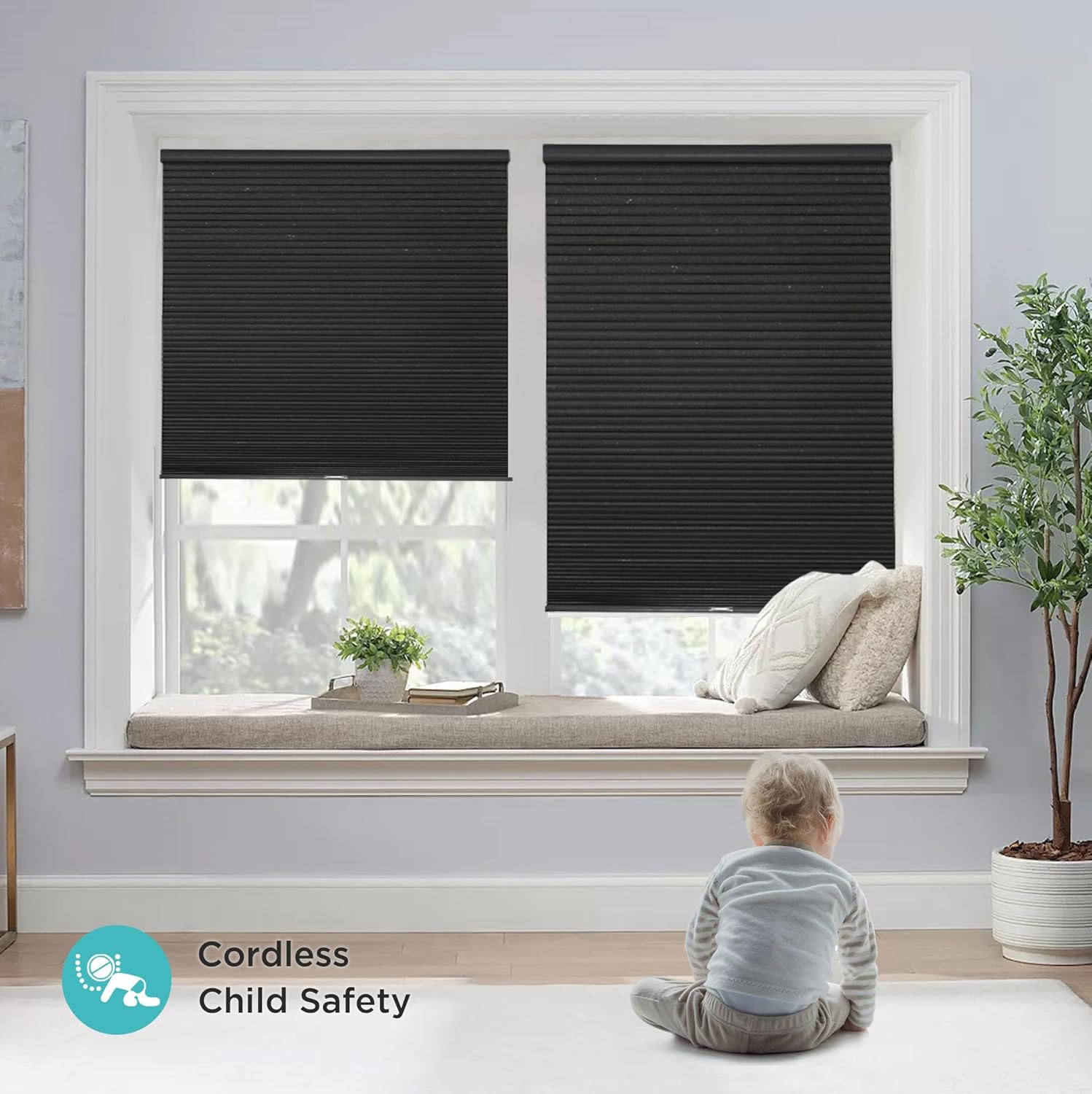 Black cordless blackout cellular shades installed on a window with a child playing nearby, emphasizing child safety.