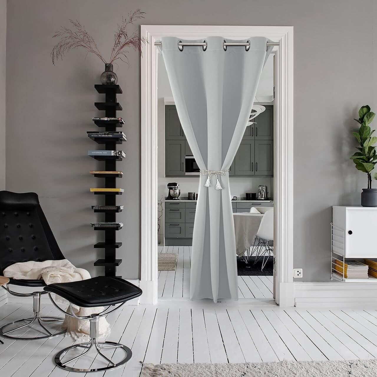 Light grey extra-wide room divider curtain with silver grommets and tassel tie-back, separating living room from kitchen.