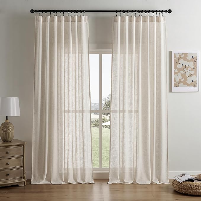 Ecru Joydeco custom linen light filtering curtains styled in a living room with a nightstand and botanical print.