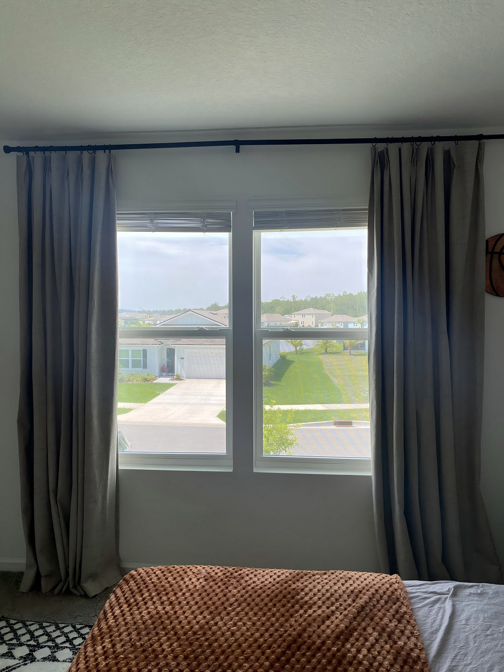 Joydeco Custom Linen Blackout Curtains in grey, flanking a window with suburban view. Textured fabric, modern design.