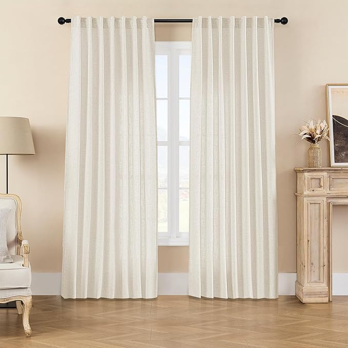 Joydeco custom off-white linen blend light filtering curtains framing a window with a chair and fireplace.