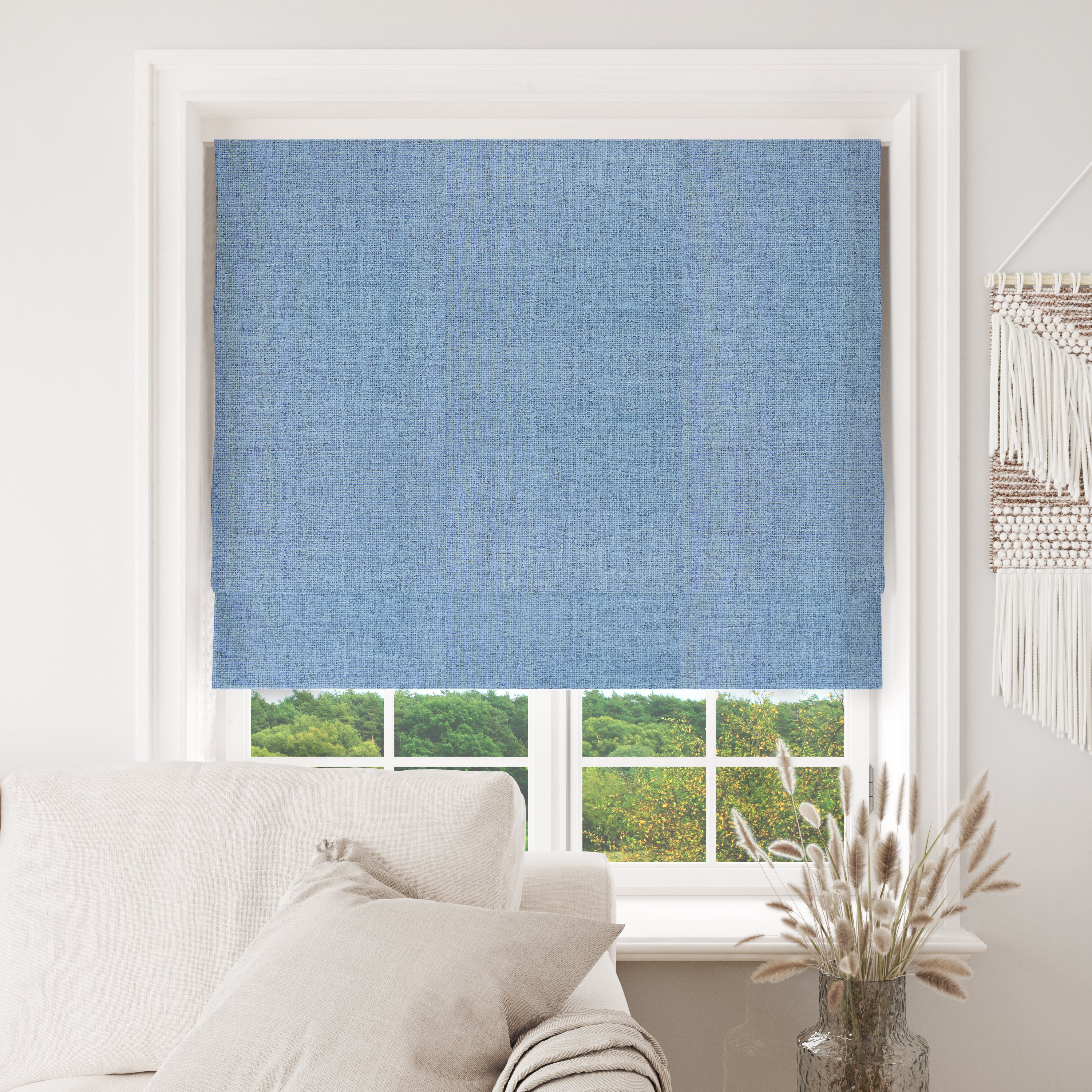 Sky blue textured blackout Roman shade in modern living room with cream sofa.