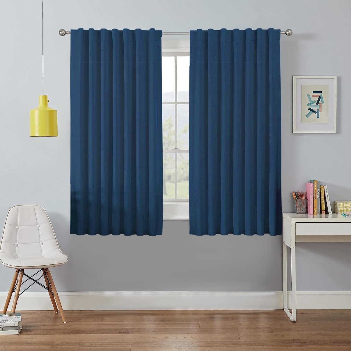Deep blue Joydeco 100% blackout curtains on silver rod. Window view with chair and desk.