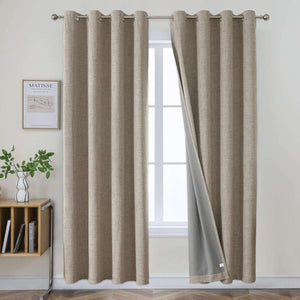 Two beige faux linen blackout curtains with grommet tops hanging on a rod, one panel slightly open to show grey liner.