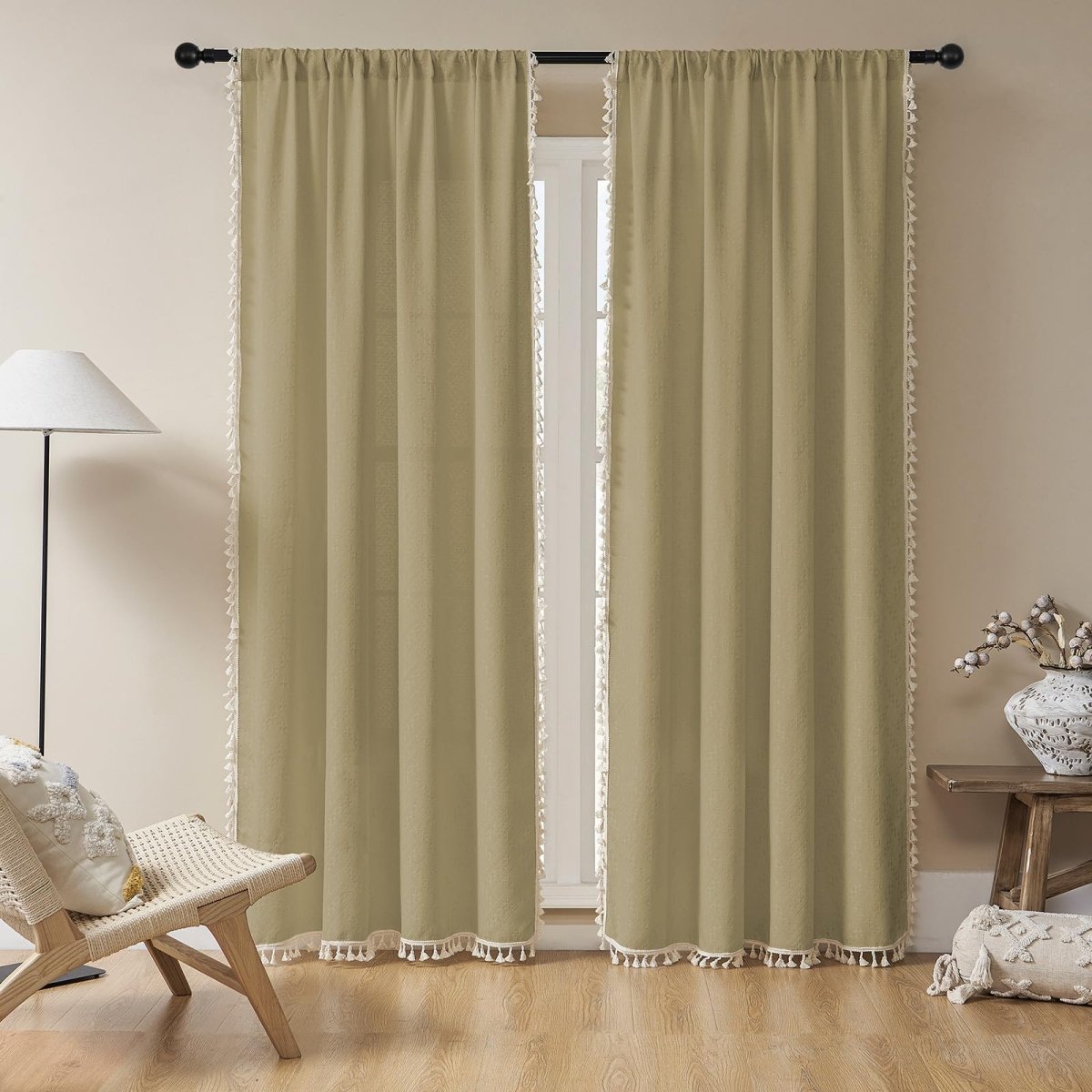 Khaki linen boho curtains with white tassels, light filtering farmhouse style, in a room with chair and lamp.