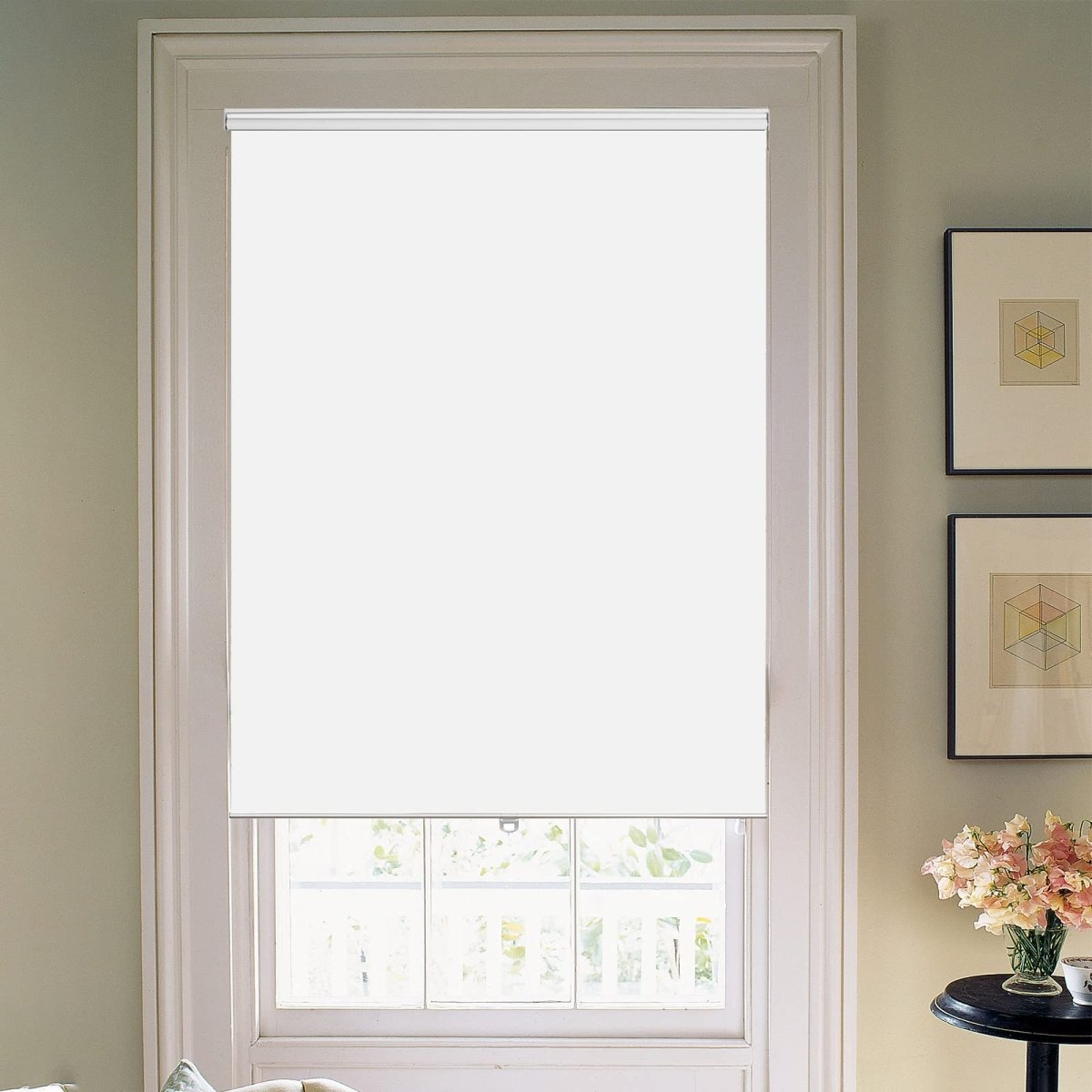 White Joydeco blackout roller shade with aluminum rod in window. Outdoor greenery visible.