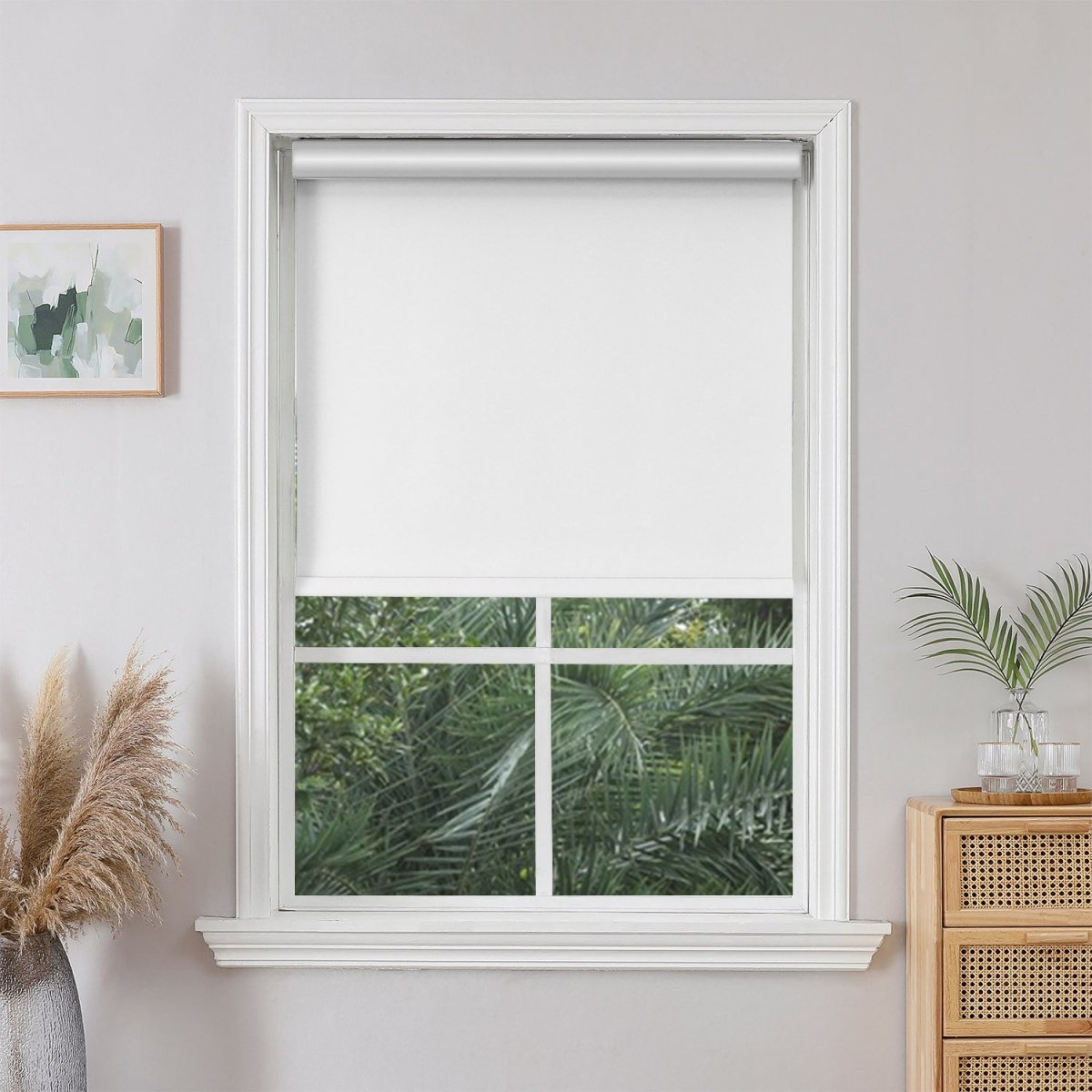 Off White Joydeco cordless blackout roller shade installed in a white window, blocking sunlight and providing privacy.