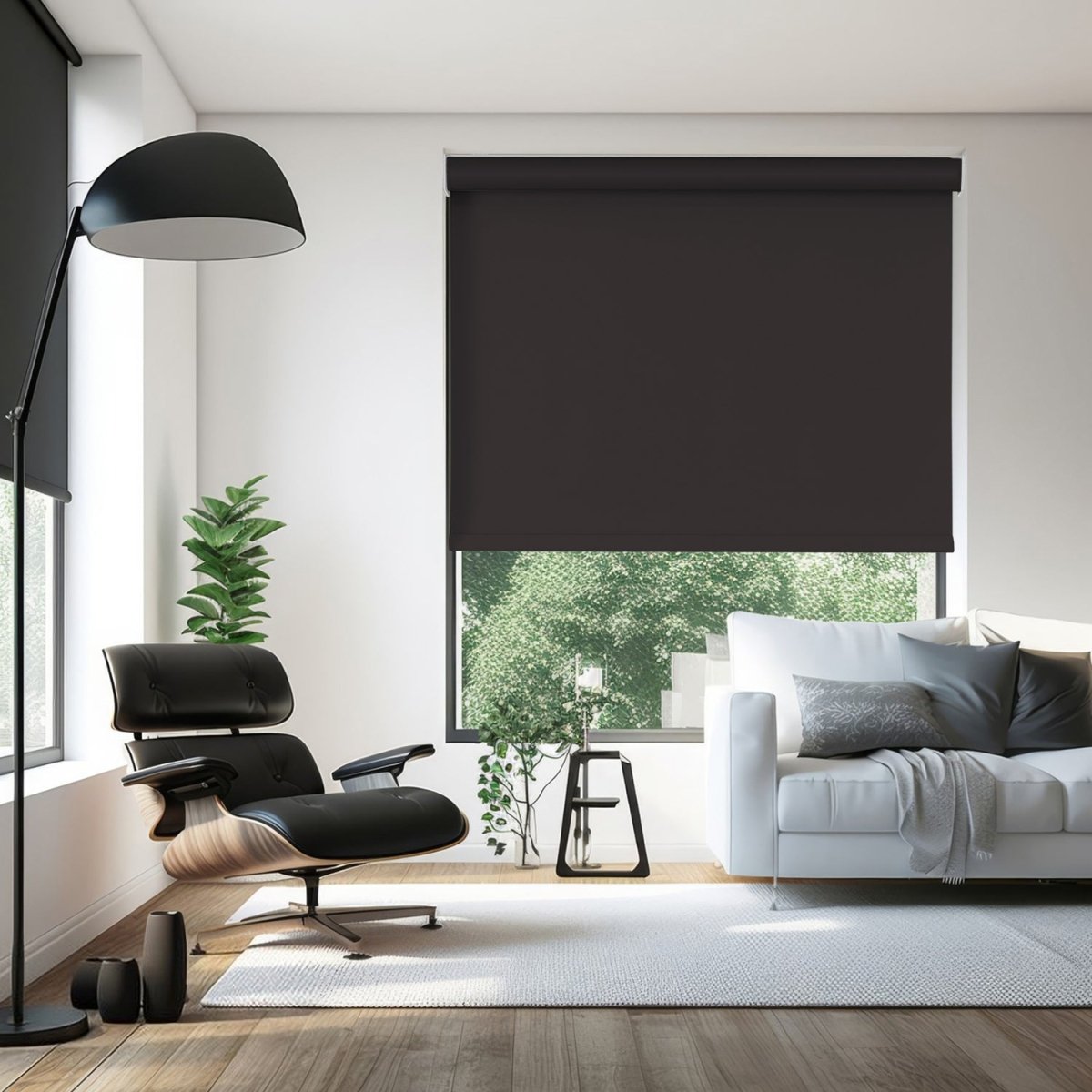 Joydeco Classic Blackout Roller Shade in dark gray, enhancing a modern living room with a black chair and white sofa.