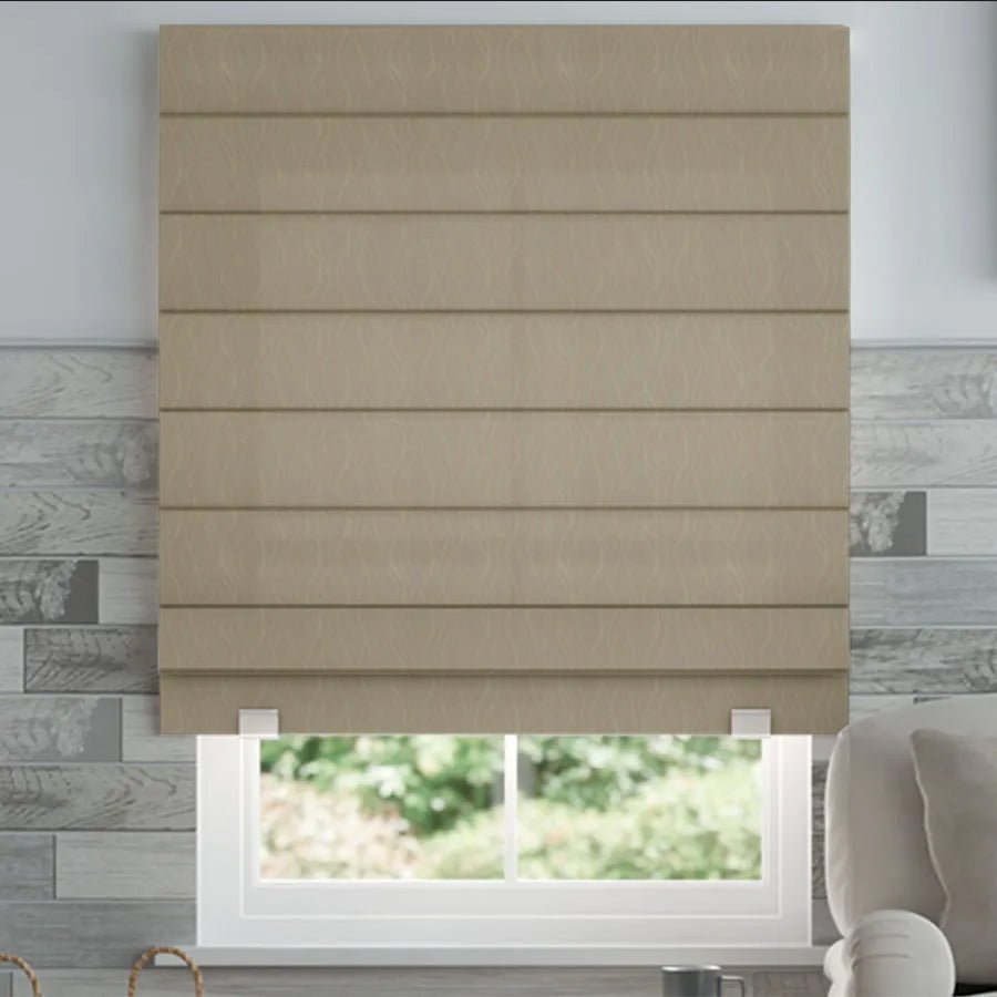 Joydeco beige textured woven Roman shade with horizontal pleats, shown on a window with a view of greenery. Armchair visible.
