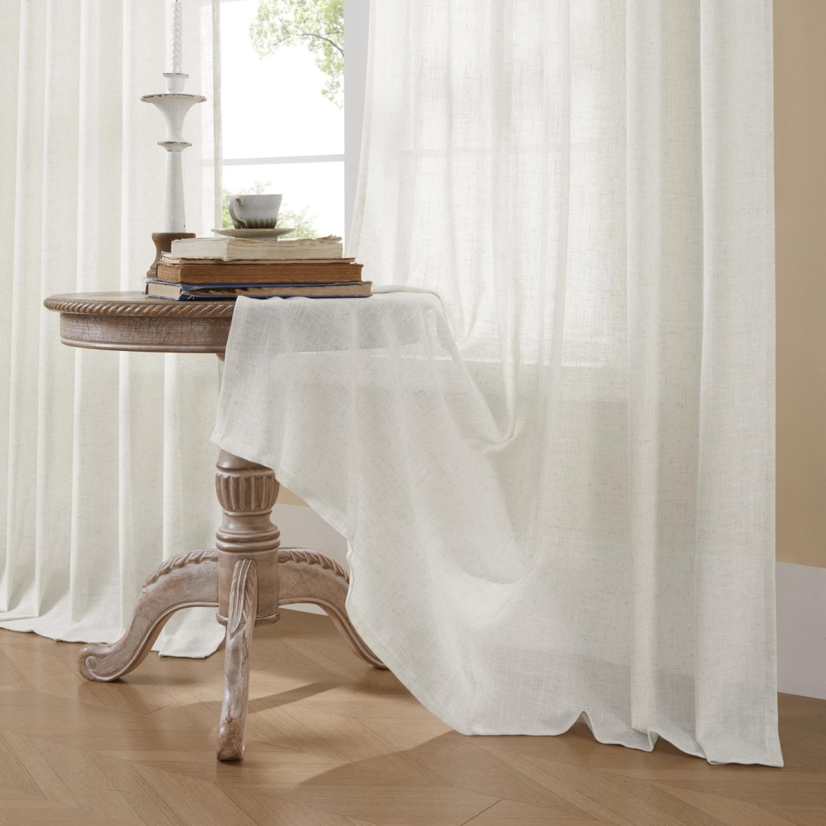 Joydeco off-white linen blend sheer curtains in a living room, diffusing light over a vintage table with books and decor.