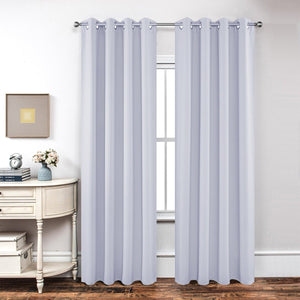 Joydeco light purple textured blackout curtains with grommet tops hanging in a room.