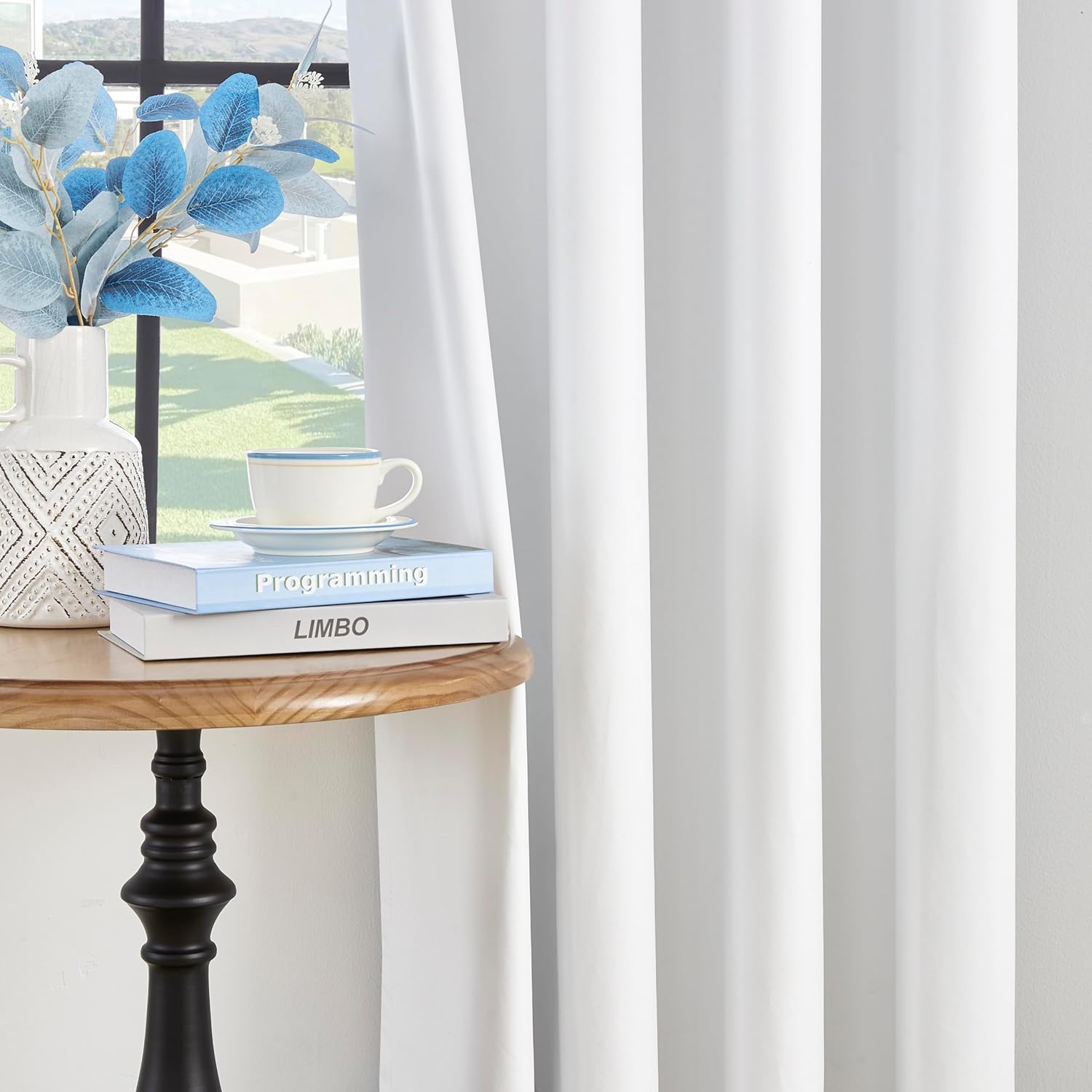 White Joydeco thermal insulated blackout curtains with grommets, shown with decor on a side table.