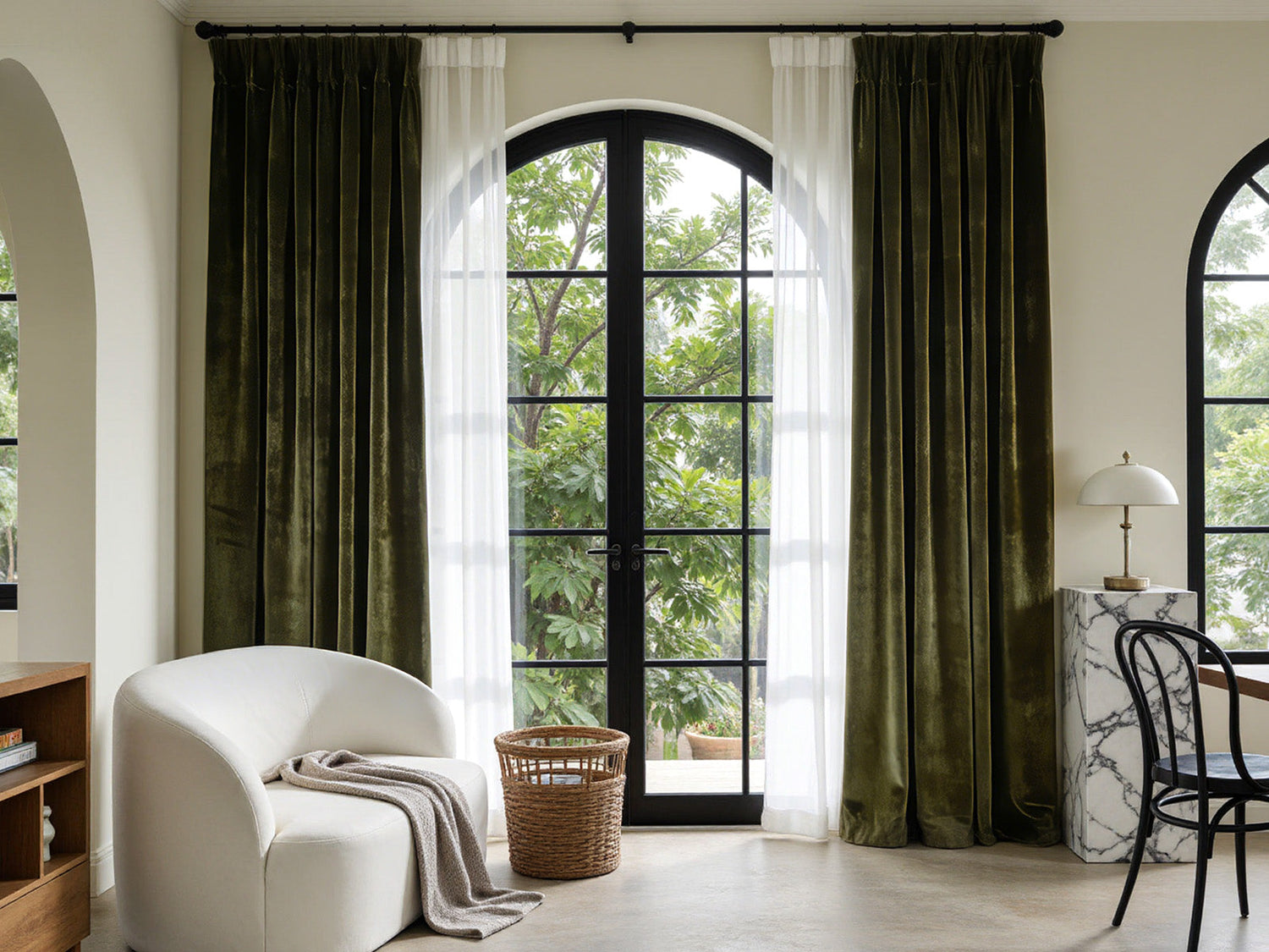 Joydeco olive green velvet curtains and white sheers on arched windows in a bright room.