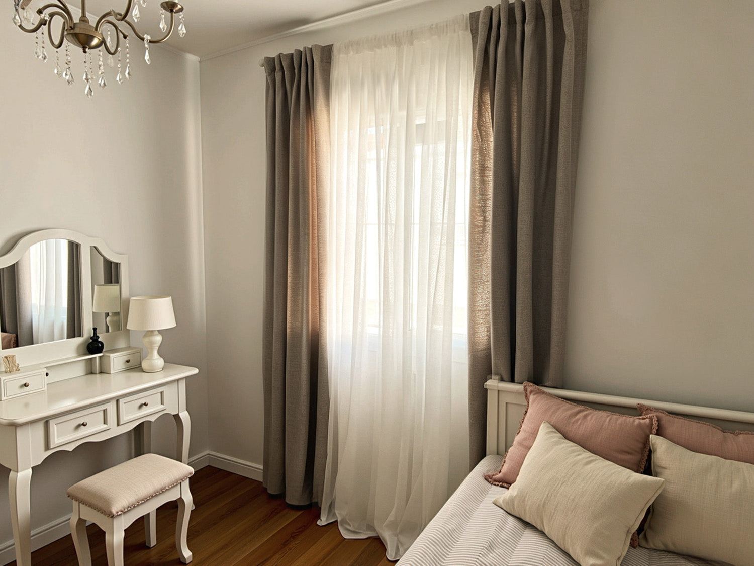 Joydeco beige panel curtains with white sheers hanging on a bedroom window.