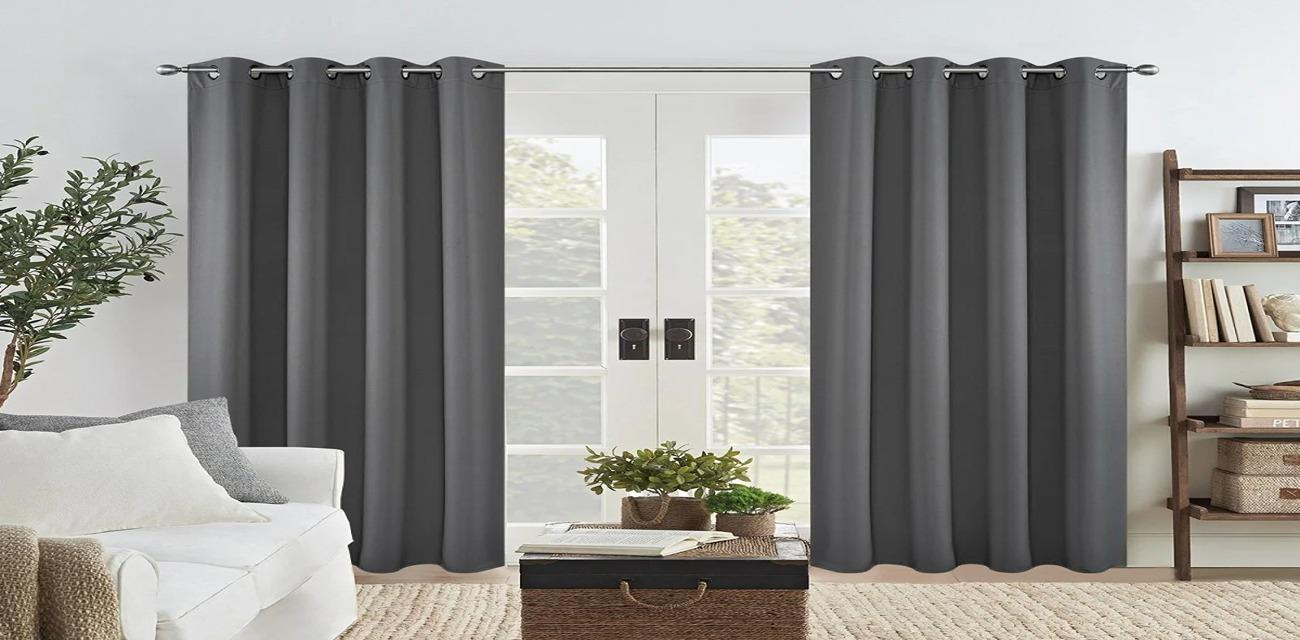 Two panels of dark gray blackout curtains drawn closed over a set of glass French patio doors.