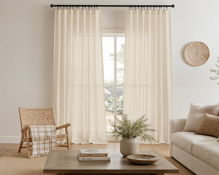 Warm beige textured sheer curtains frame the window in a cozy natural-style living room, creating a relaxed, airy atmosphere.