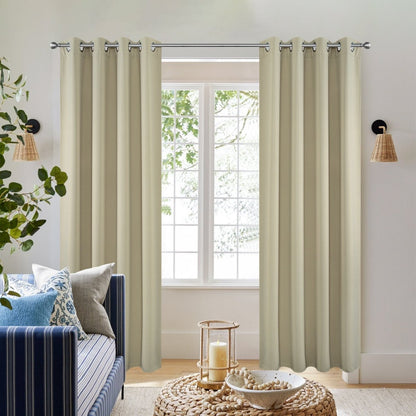 Beige Joydeco blackout curtains with grommets shown in a living room with a blue sofa.