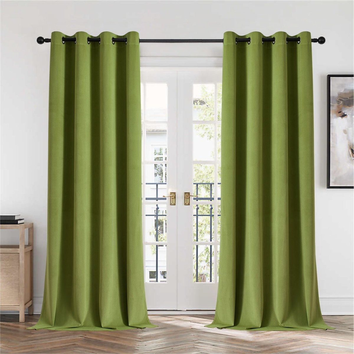 Two moss green velvet blackout curtains with grommets hanging on French doors, showcasing plush texture.