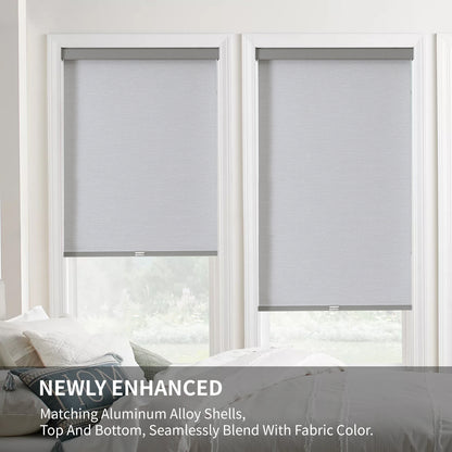 Two light gray cordless blackout roller shades with matching aluminum alloy valance, inside mount on white window frame.