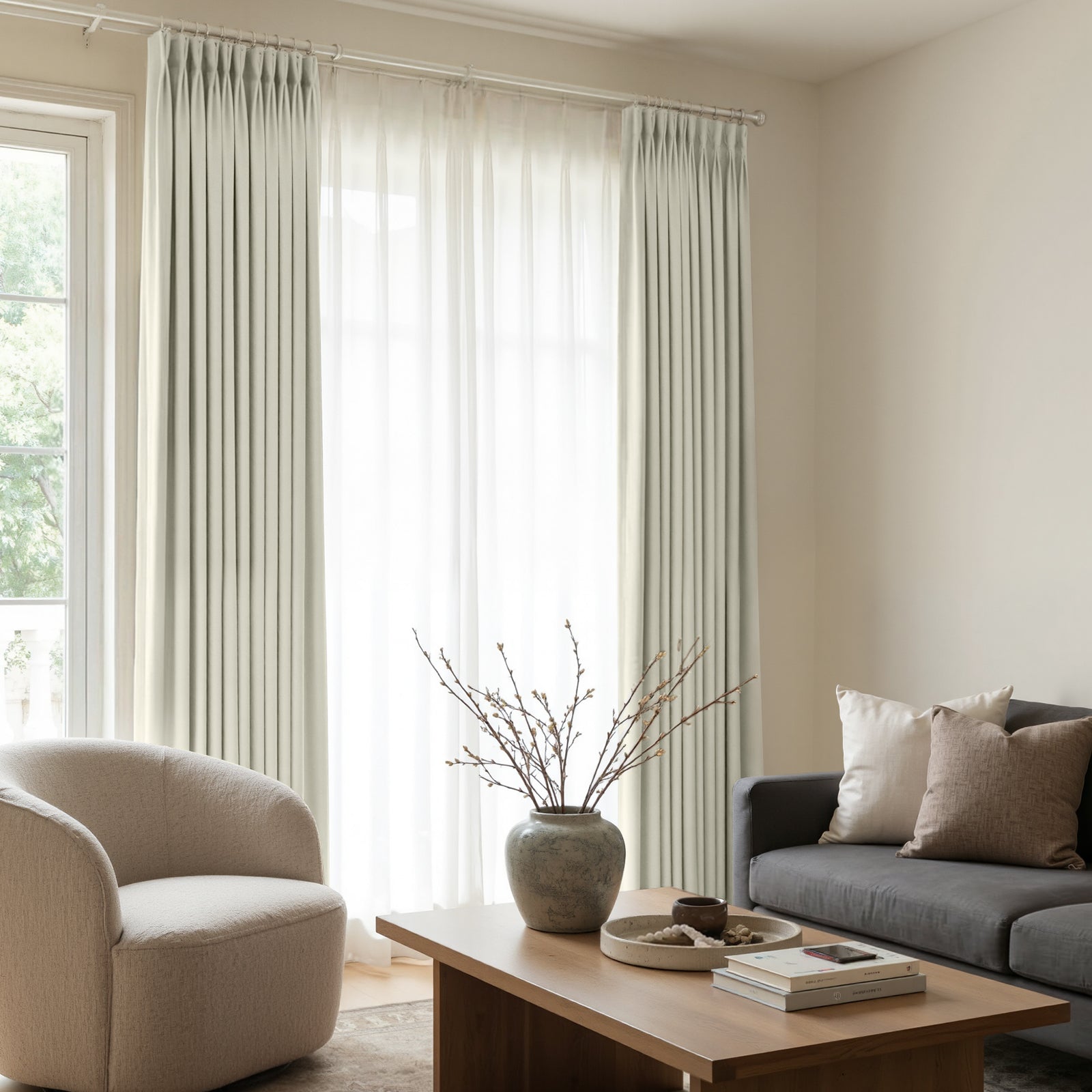 Custom Arden Satin Blackout Curtain in light neutral color, elegantly pleated and layered with sheer curtains for home decor.