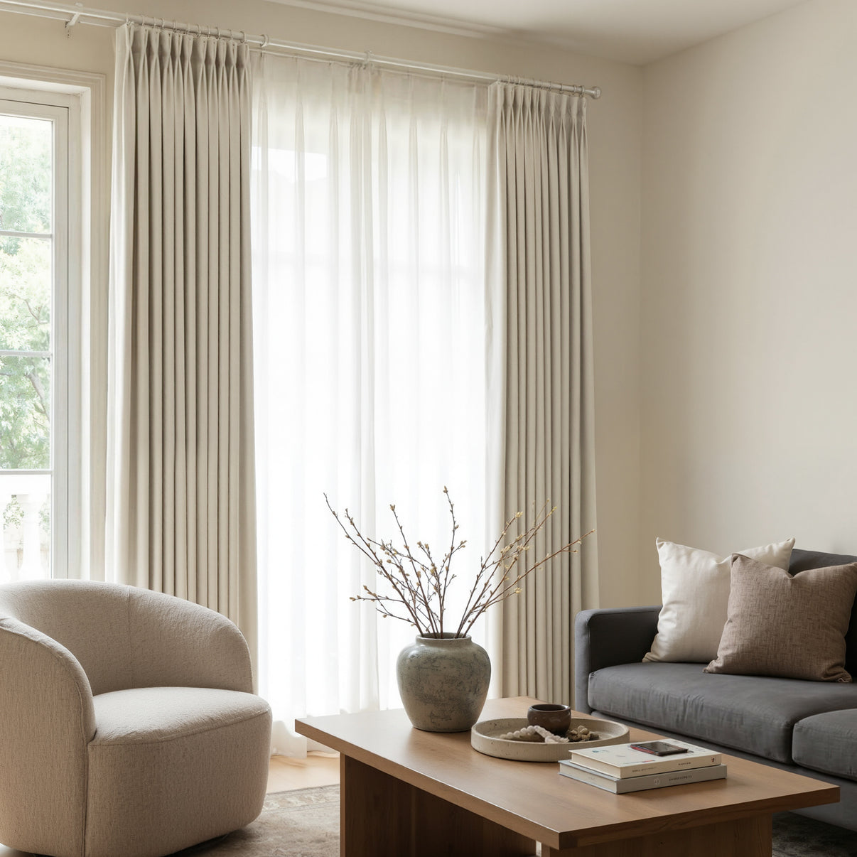 Joydeco Arden Satin Blackout custom curtain in elegant beige pleats, shown in living room.