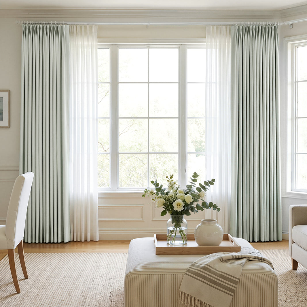 Hayden pale green custom blackout curtains layered over sheer white panels.