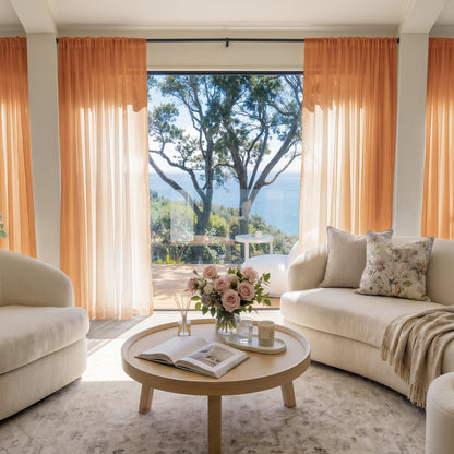 Peach sheer custom curtains creating an airy living room ambiance with an ocean view.