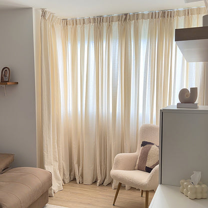 Joydeco cream semi-sheer linen blend curtains with rod pocket, filtering light in a modern living room with armchair.
