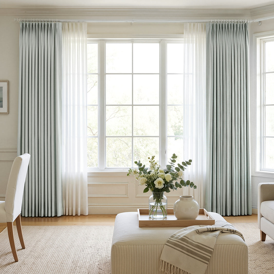 Soft blue-grey Hayden Chenille blackout curtains layered with sheer drapes.