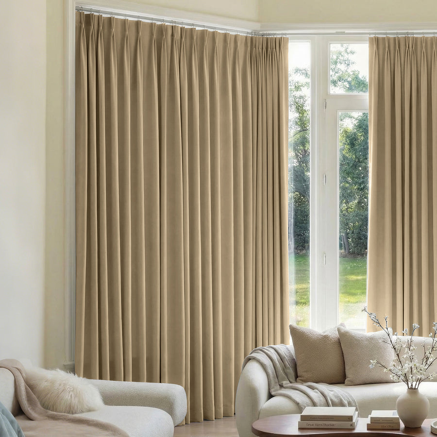 ###default
Beige custom triple weave pleated blackout curtains in a living room.