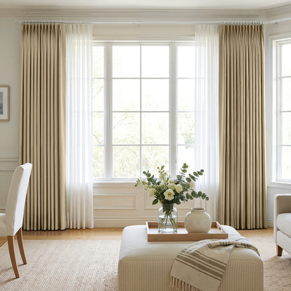 Custom beige chenille blackout curtains with sheer panels on bay window.
