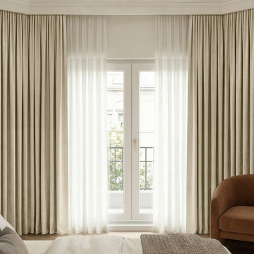 Beige Chenille blackout curtains layered with sheer curtains for custom window treatments.