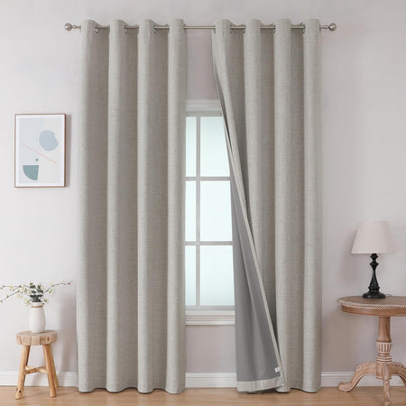 Greyish white faux linen blackout curtains with grommets, double layered, blocking sunlight for a bedroom or living room.