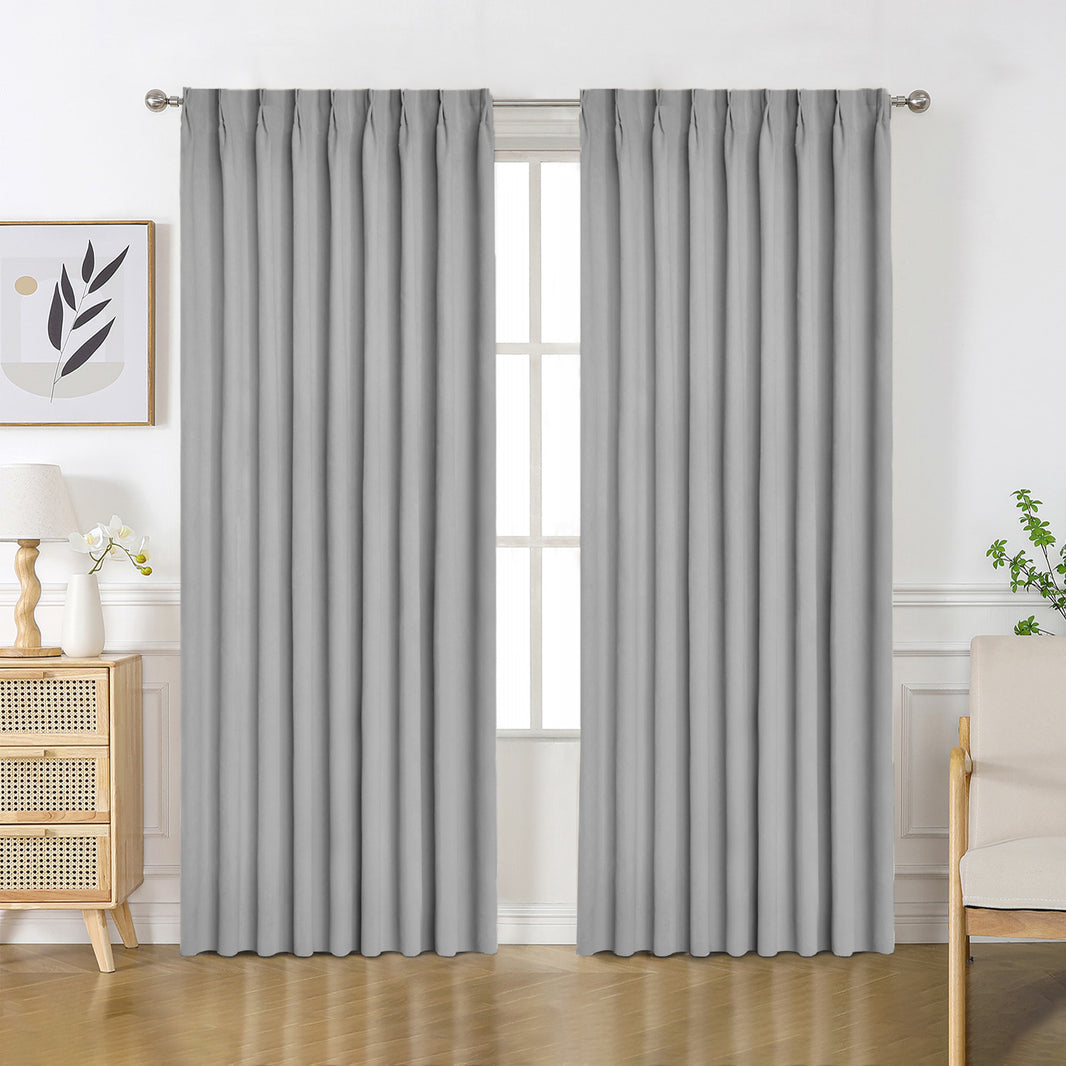 Custom light gray chenille blackout curtains with grommet tops in a bright room.