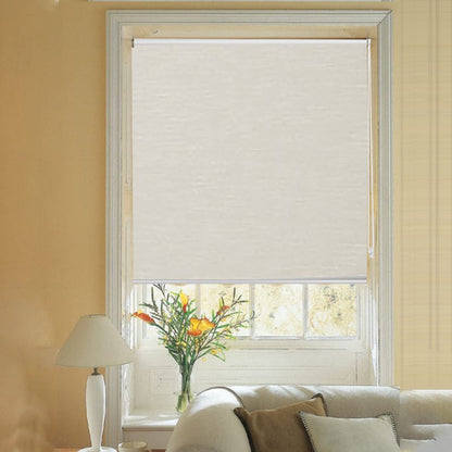 Cream striped jacquard cordless blackout roller shade partially lowered in a living room with floral arrangement.