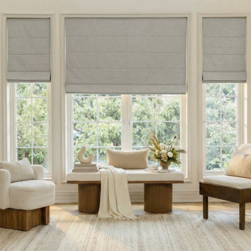 Grey faux linen blackout Roman shade with tailored folds, ideal custom window treatment.