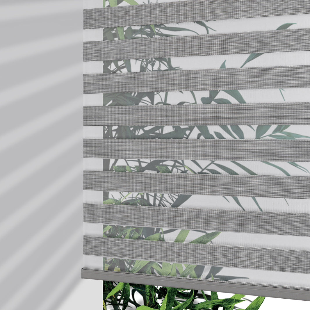Joydeco Pro cordless zebra blinds in grey stripe pattern with leaf motif, partially lowered to show light filtering effect.