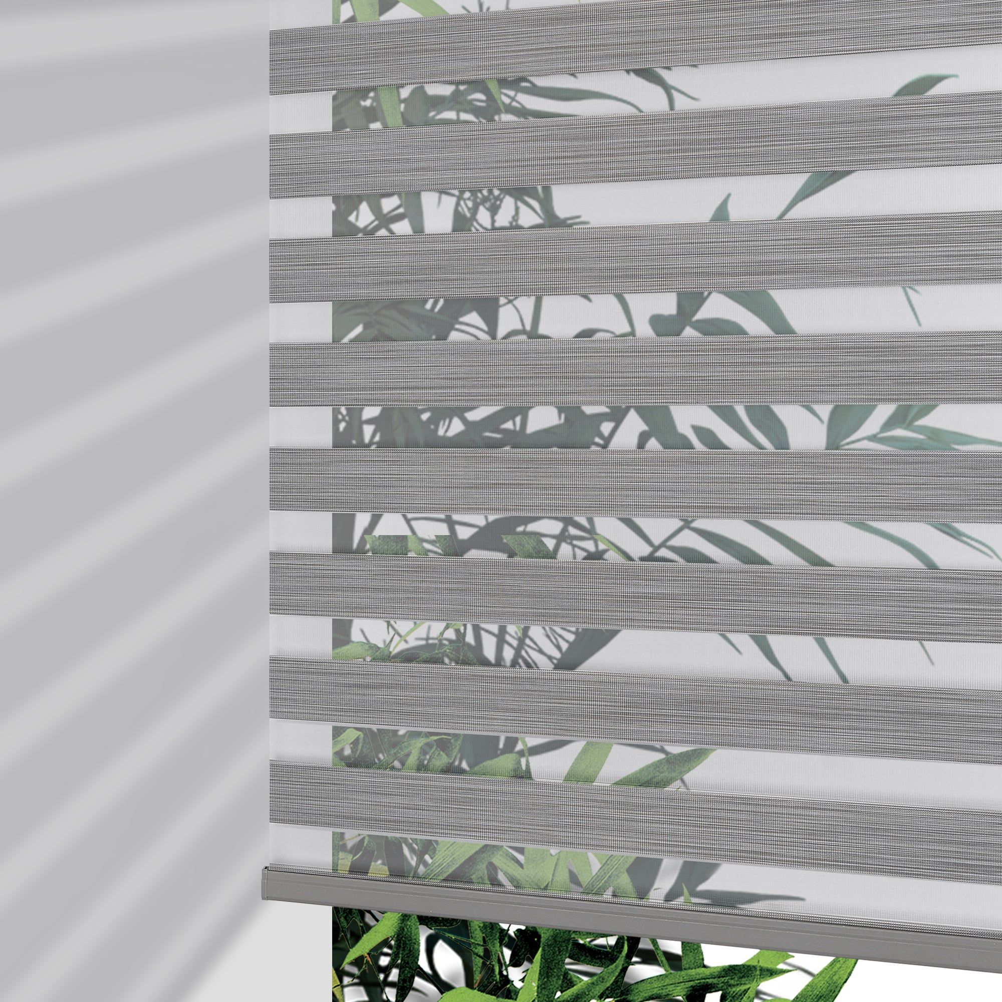 Joydeco Pro cordless zebra blinds in grey stripe pattern with leaf motif, partially lowered to show light filtering effect.