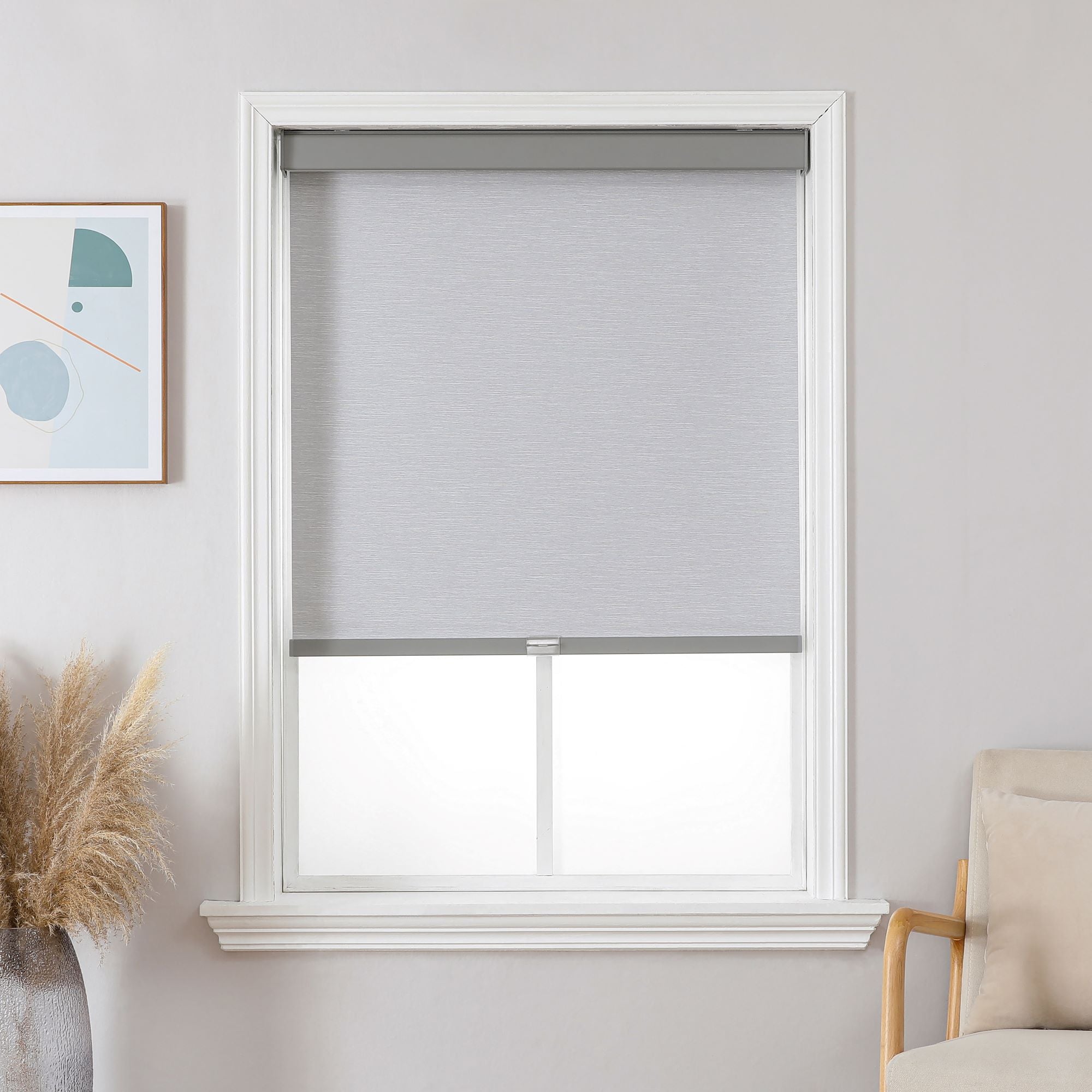 Gray cordless blackout roller shade, free-stop system, inside mount on white window.