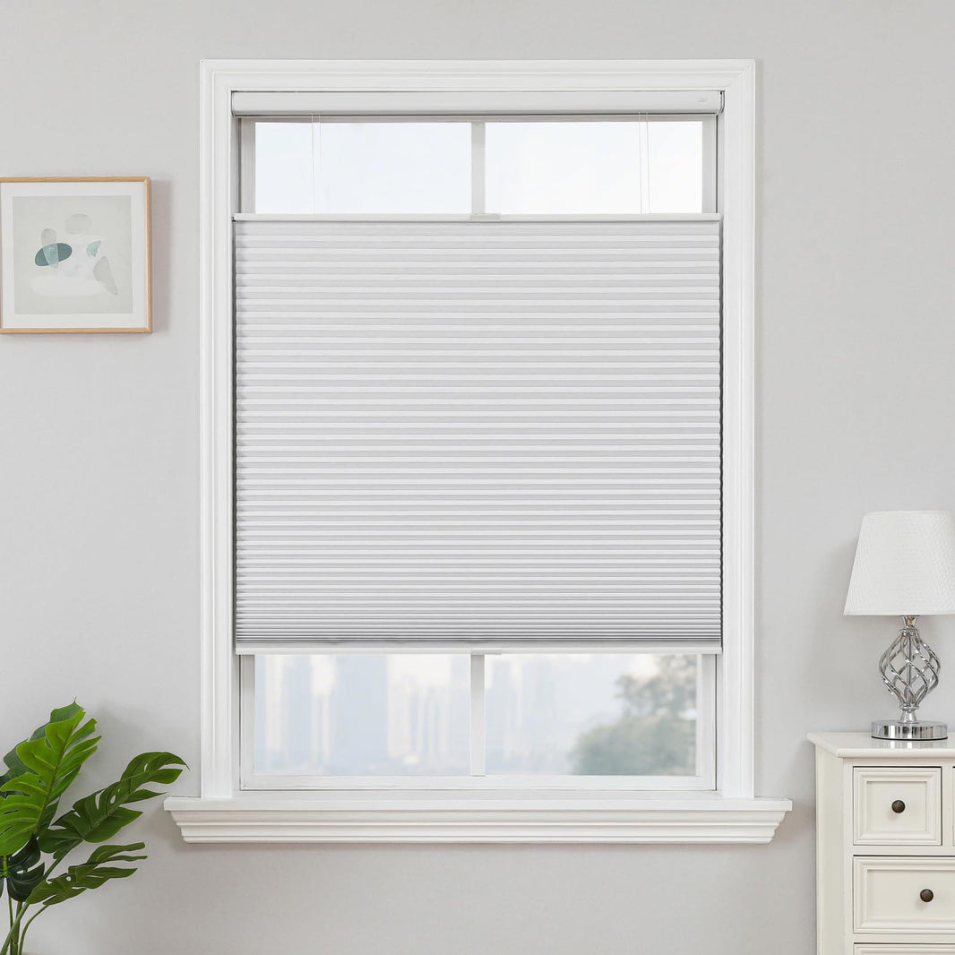 White cordless blackout honeycomb shades with top-down bottom-up feature in a window.