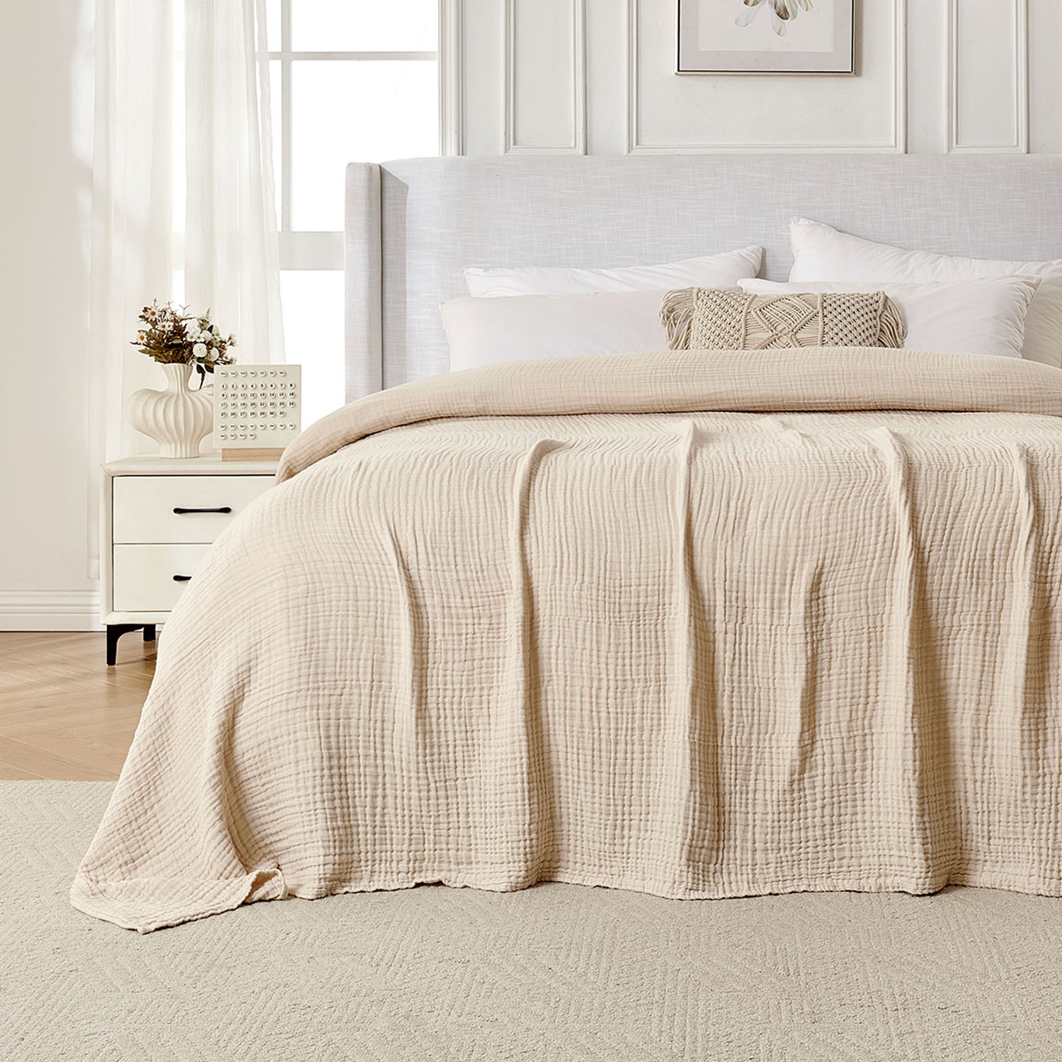 Beige 4-layer cotton muslin throw blanket with gauze texture on a bed.