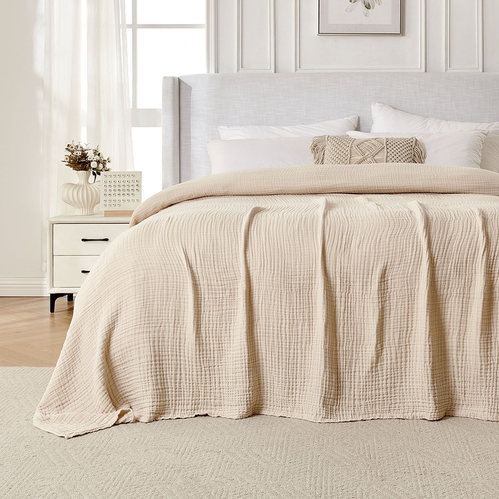 Beige 4-layer cotton muslin throw blanket with gauze texture on a bed.
