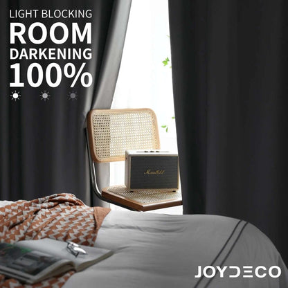 Joydeco dark grey blackout curtains showing 100% light blocking in a bedroom setting. Thermal insulated.