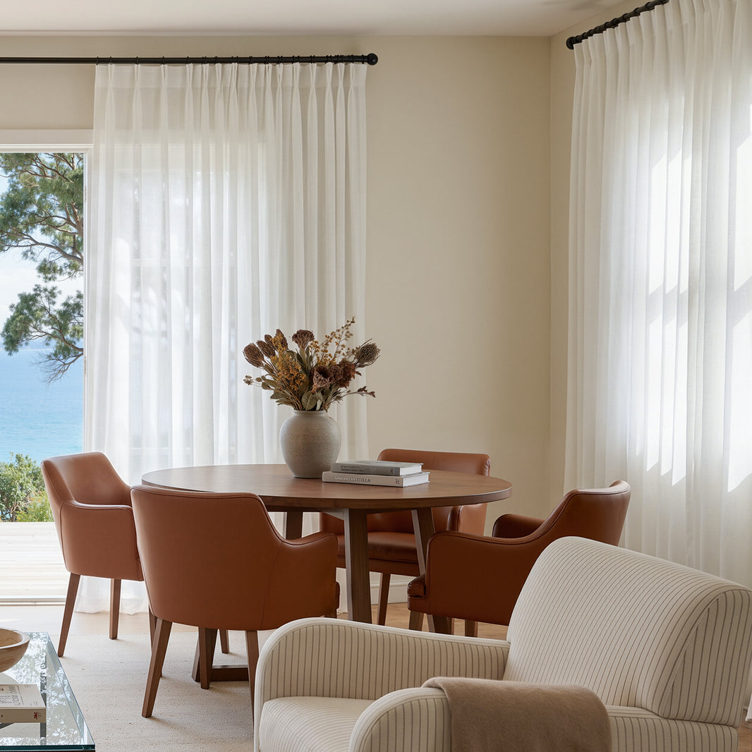 Custom lightweight sheer curtains create a bright, airy atmosphere with ocean view.