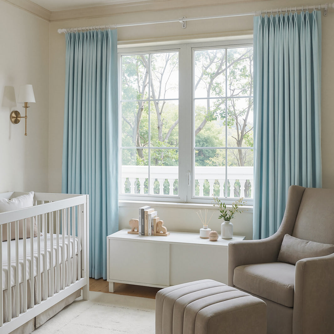 Light blue custom pleated blackout curtains in a nursery.